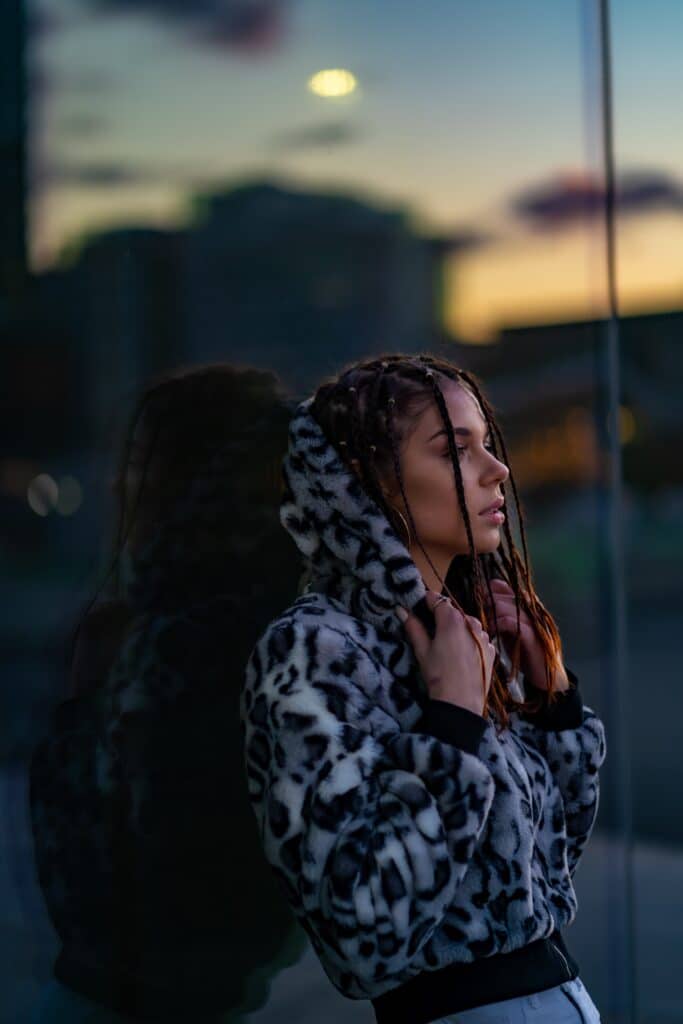 a woman with dreadlocks standing in front of a window