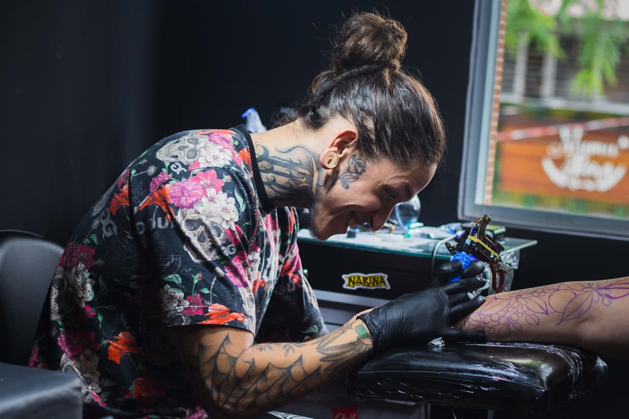 tattoo artist tattooing an arm