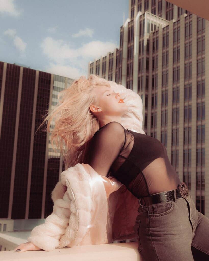 woman leaning against wall on city rooftop