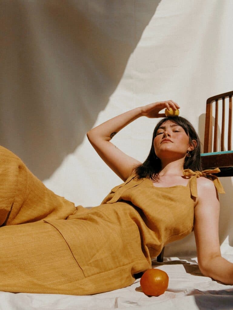 woman lying on floor wearing mustard yellow jumpsuit