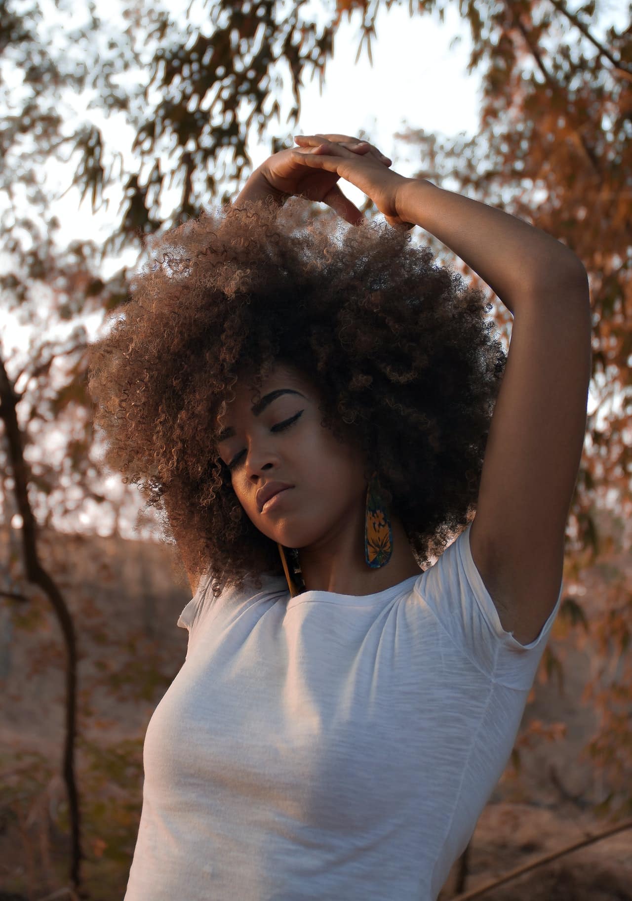 woman with eyes closed in the outdoors